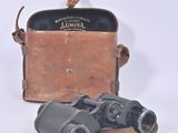 an old pair of binoculars sitting on top of a leather case