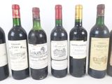 several bottles of wine are lined up in a row on a white surface