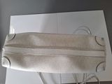 beige leather handbag with silver hardware on top of a white box
