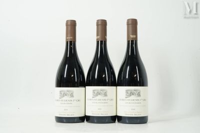 trois bouteilles de vin rouge sont alignées sur une surface blanche