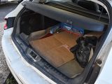 a box of pizza in the trunk of a car