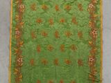a green table cloth with a floral design on it