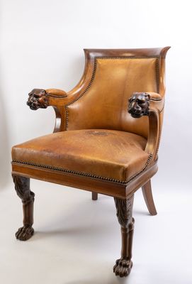 an image of a brown leather chair with a lion head on the arm