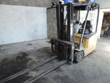 un chariot élévateur garé dans un garage, à côté d'un mur de briques