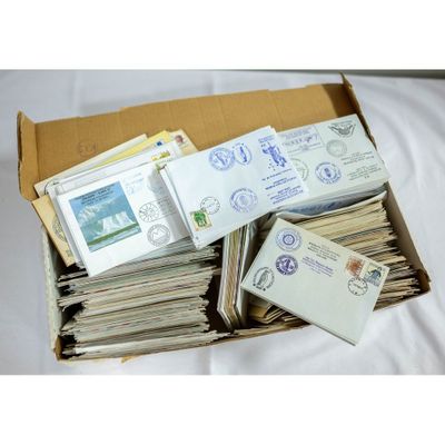 a box full of stamps and envelopes sitting on a bed