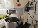 a mixer on a counter in a kitchen with a lot of clutter