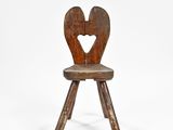 an old wooden chair with a heart cut out of the back