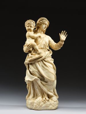 a carved ivory figurine of a woman holding a child