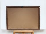 a wooden easel with a painting on it in front of a white wall