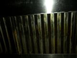 a close up of a metal grill hood with a light shining on it