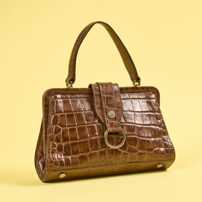 sac à main en cuir de crocodile marron sur fond jaune