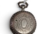a silver pocket watch hanging on a white string