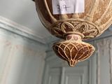 a brown vase hanging from the ceiling with a sticker on it