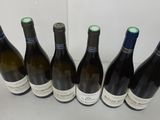 six bottles of wine are lined up in a row on a table