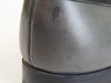 the back of a pair of black shoes on a white surface