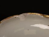 a close up of a white bowl with a gold rim