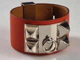 un bracelet en cuir rouge orné de clous argentés