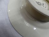 a white plate with a bowl on it on a table