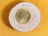 a small coin sitting on top of a piece of wood