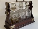 une carafe en verre contenant quatre bouteilles, posée sur un support