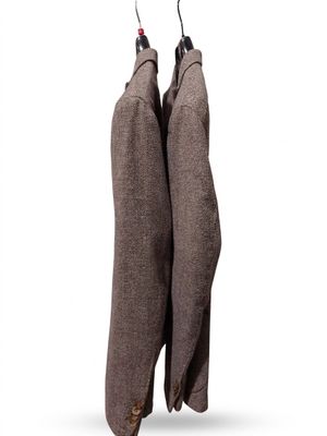 two coats hanging on a clothes rack on a white background