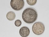 several coins are arranged in a circle on a white surface