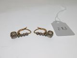 a pair of gold and diamond earrings