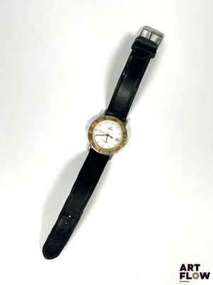 une montre posée sur une surface blanche