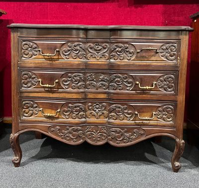 une commode en bois dans une pièce aux murs rouges