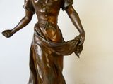 statue en bronze représentant une femme tenant une fleur dans la main droite