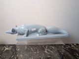 une statue bleue représentant un chien couché sur une table