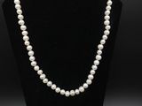 un collier de perles blanches sur un mannequin noir