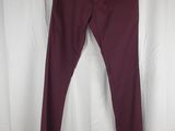 a pair of burgundy colored jeans hanging on a hanger