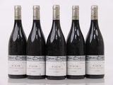 six bouteilles de vin sont alignées sur une table