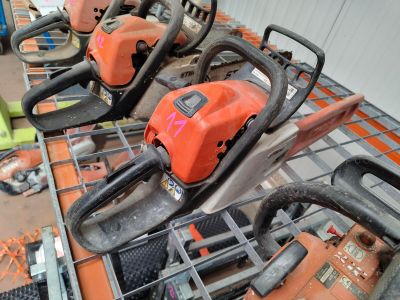 several chainsaws are lined up on a table in a warehouse