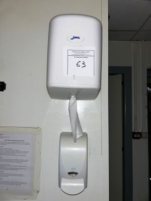 a white paper towel dispenser hanging on the wall