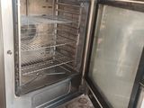 a small oven with a door open in a garage