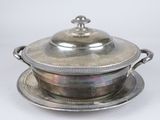 an antique silver plate with a lid and a saucer on it