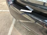 a sticker on the bumper of a car that is parked in a parking lot