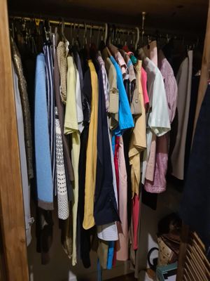 beaucoup de vêtements suspendus à un portant dans un placard