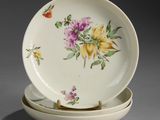 two plates with flowers on them sitting on a table