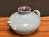a blue vase sitting on top of a wooden table