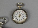 a pocket watch and a keychain on a table