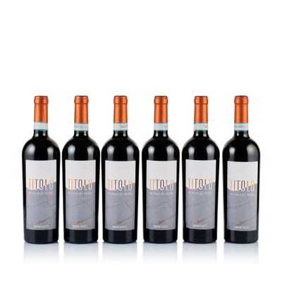 three bottles of red wine are lined up on a white surface