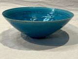 a blue bowl sitting on a table with a white background