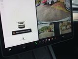 a car dashboard with a monitor showing a picture of a car