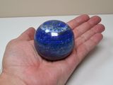 a person holding a blue marble ball in their hand