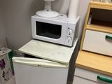 un micro-ondes blanc posé sur un réfrigérateur blanc