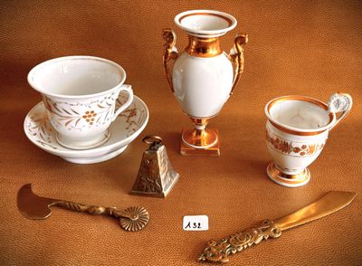 a gold and white tea set on a brown table