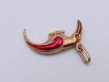a gold and red pendant with a crescent on it